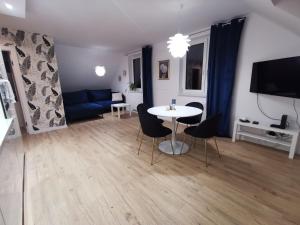 a living room with a table and a blue couch at Złoty Apartament - Okrzei z miejscem parkingowym, dostęp 24H, Klimatyzacja in Kielce