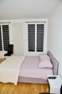 1 dormitorio con 1 cama grande y 2 ventanas en STUDIO JASMIN en París