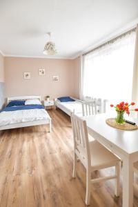 1 dormitorio con 2 camas, mesa y sillas en Apartament Zosienka en Zator