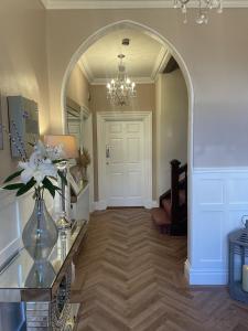 a hallway with an archway and a vase of flowers on a table at Wheatlands Lodge Guesthouse - Adults Only - Free car park - Licensed Venue in Windermere