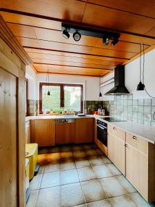 a large kitchen with wooden cabinets and a window at Ruhestifter-Salem mit Aromasauna und Hot Tub bis zu 10 Personen in Salem