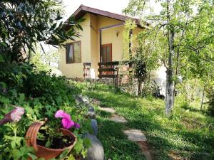 een klein huis met een tuin ervoor bij Yellow villa in Sinemorets