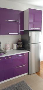 a kitchen with purple cabinets and a stainless steel refrigerator at Apartman Aura in Zagreb