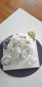 a white plate with white flowers on a table at Apartman Aura in Zagreb
