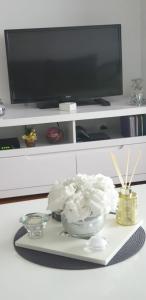 a tray with a bowl of flowers on a table with a tv at Apartman Aura in Zagreb