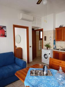 Appartamento Stela في كالاسيتا: غرفة معيشة مع أريكة زرقاء وطاولة