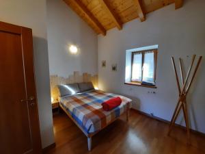 1 dormitorio con 1 cama en una habitación con ventana en Maso Daü, en Marter di Roncegno