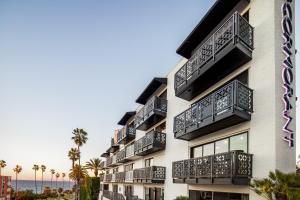 a building with balconies and the ocean in the background at Cormorant Boutique Hotel in San Diego