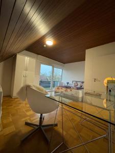 um quarto com uma mesa de vidro e uma cadeira em FlyHigh Apartment Stuttgart em Stuttgart