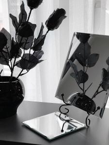 a table with a vase with flowers and a pair of scissors at Pristina City Apartment in Pristina