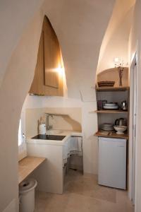a small kitchen with a sink and an archway at Casetta del vicolo orologio in Cisternino