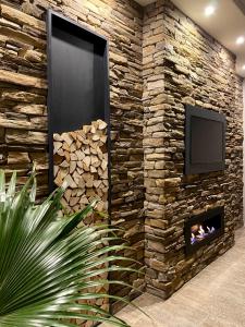 pared de piedra con TV y chimenea en Ta Lucija - Luxurious 6 Bedroom/En suite Villa - Pool / AC en Santa Luċija