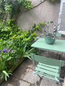 a green table in a garden with plants at L' ALCOVE- Confort Charme Downtown in Dijon +41 photos