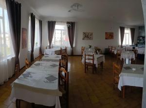 a dining room with tables and chairs with white tablecloths at Hotel Baiardo in Romagnano Sesia