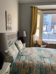 a bedroom with a bed and a window at The Beaches En-Suite Rooms in Redcar