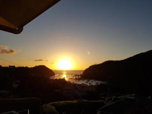 a sunset over a body of water with the sun setting at Casa Vista in Marigot Bay