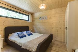 a bed in a wooden room with a window at Ostoja Orżyny, Dom nr 1 - W stronę jeziora in Orzyny