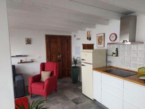 uma cozinha com uma cadeira vermelha ao lado de um balcão em Bungalowmirador em Fuencaliente de la Palma