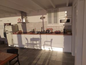 a kitchen with white cabinets and a table and chairs at Bungalowmirador in Fuencaliente de la Palma