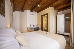 a bedroom with a white bed and a bathroom at Hotel Natura Vilanija in Umag