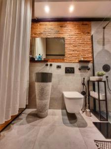 a bathroom with a toilet and a television in it at LOFT8 Wonderful industrial loft in Turin in Turin