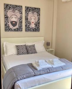 een slaapkamer met een bed met twee foto's aan de muur bij Taormina Center Private Apartments By Fragranza Di Sicilia in Taormina