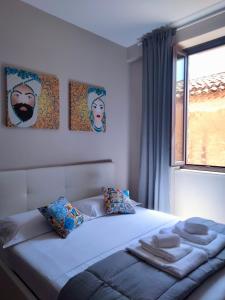a bedroom with a large bed with a window at Taormina Center Private Apartments By Fragranza Di Sicilia in Taormina