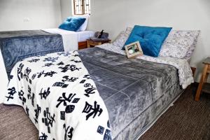 a bedroom with two beds and blue pillows at Casa de Campo, Rincón de Paz entre Montañas y Paisajes Verdes in Sogamoso