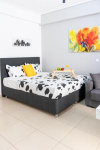 a bed in a white room with a cow print sheets at C3 Modern Spartan Apartment in Sparti