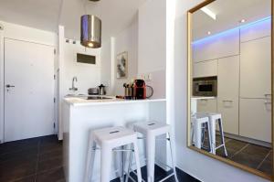 kuchnia z 2 stołkami i lustrem w obiekcie Precioso apartamento con vistas al mar y piscinas w mieście Benalmádena