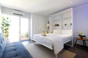 sypialnia z białym łóżkiem i niebieską kanapą w obiekcie Precioso apartamento con vistas al mar y piscinas w mieście Benalmádena