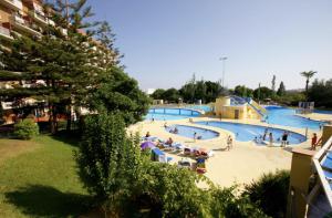 duży basen z osobami w ośrodku w obiekcie Precioso apartamento con vistas al mar y piscinas w mieście Benalmádena