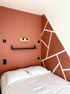 漢斯的住宿－Studio design au centre de Reims，卧室配有白色的床和橙色的墙壁