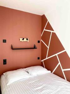 a bedroom with a white bed and a orange wall at Studio design au centre de Reims in Reims