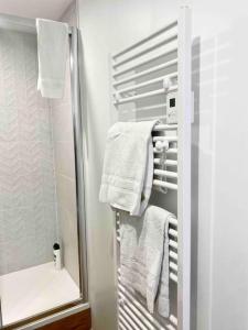 a bathroom with white towels on a towel rack at Studio design au centre de Reims in Reims +10 photos