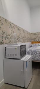 a microwave on top of a dresser in a bedroom at El Colmenar Hospedaje in Madrid