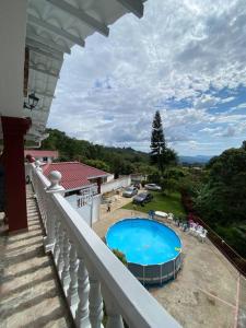 een balkon van een huis met een zwembad bij Finca privada con excelente clima, rio natural, wifi y piscina in Cachipay