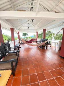 een veranda met stoelen en een hangmat in een kamer bij Finca privada con excelente clima, rio natural, wifi y piscina in Cachipay