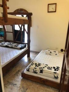 twee stapelbedden in een kamer met een klok aan de muur bij Finca privada con excelente clima, rio natural, wifi y piscina in Cachipay