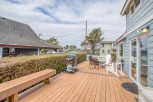a wooden deck with a bench and a grill at By The Sea in Lincoln City