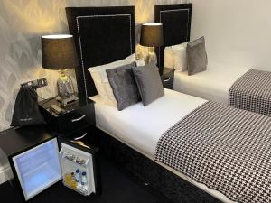 una camera d'albergo con due letti e un tavolo con specchio di Sunnyside Guest House Southport a Southport