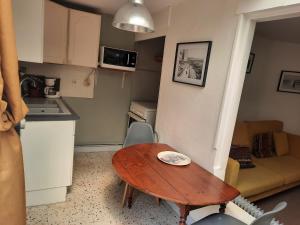 una pequeña cocina con mesa de madera en una pequeña habitación en p'tite maison entre mer et campagne en Wimille