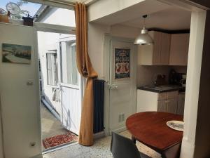 una pequeña cocina con una mesa y una puerta abierta en p'tite maison entre mer et campagne, en Wimille