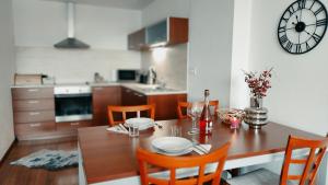 a dining room table with chairs and a clock on the wall at Nicole Apartment Donovaly in Donovaly