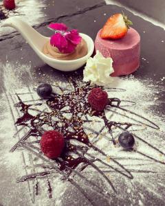 a chocolate dessert with a strawberry and berries on a table at The Castle Inn in Usk