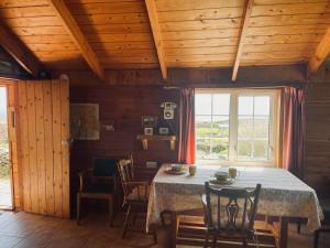 a dining room with a table and chairs at Dave's Wee House in Kilcar