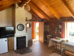 a living room with a fireplace and a table with a tableablish at Dave's Wee House in Kilcar