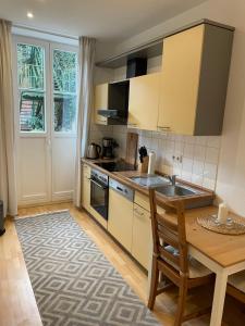 a kitchen with a wooden table and a sink at Unterkunft direkt an der Schelfkirche in Schwerin