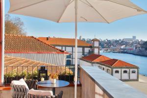 uma varanda com uma mesa e um guarda-chuva em Wonderful Porto Design Apartments no Porto