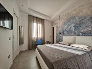 馬達萊納的住宿－Capricci di Vento - Design Guest House，一间卧室配有一张大床和一张蓝色椅子